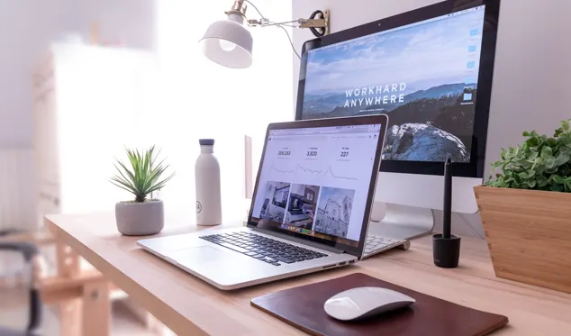 A home office desk with a laptop and monitor